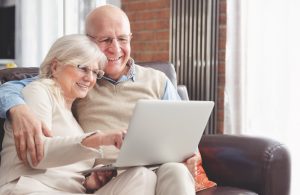 Couple using laptop computer to research the best place to retire. 